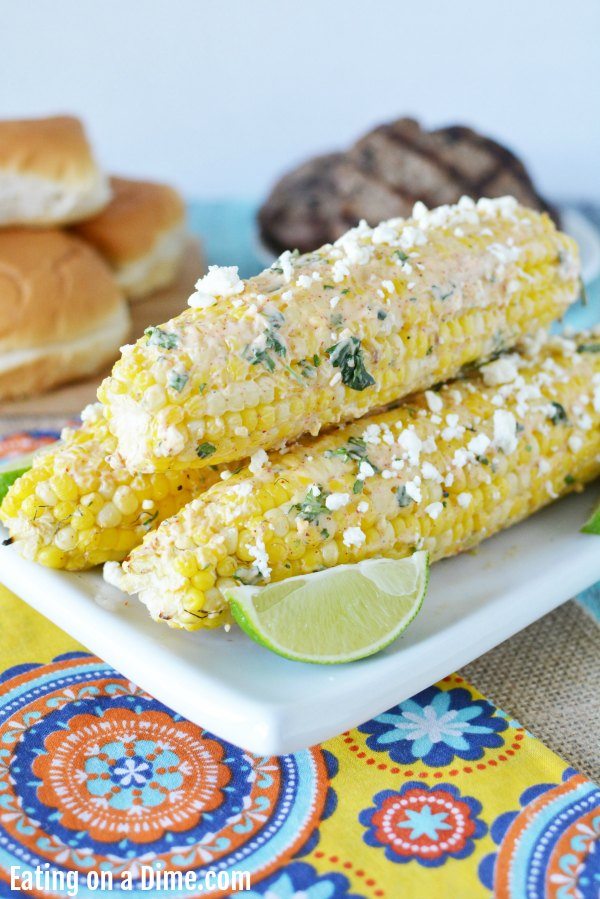 Close up image of Mexican Corn on the Cob on a white plate. 