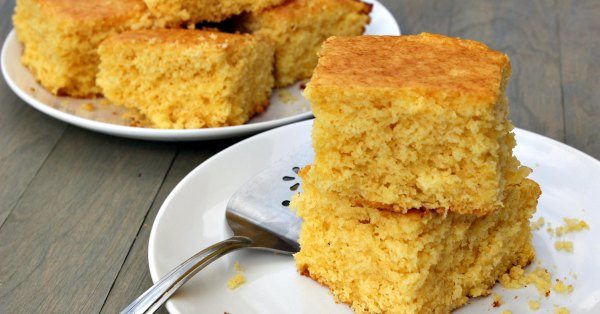 Close up image of cornbread on a white plate. 