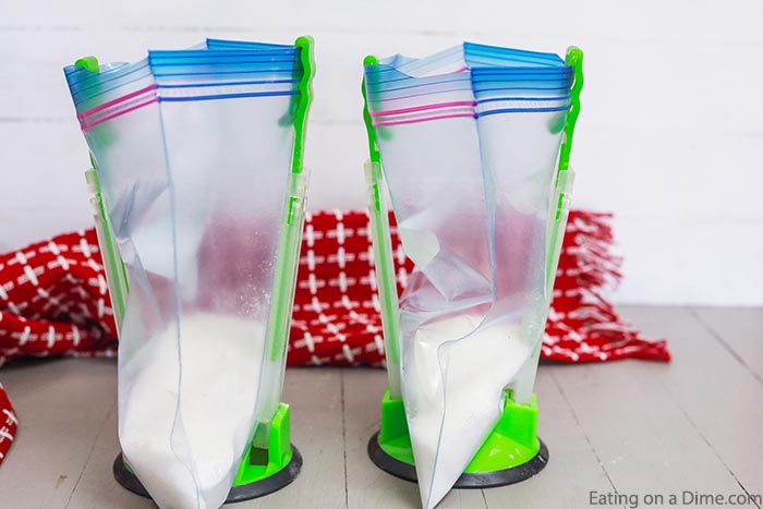 Close up image of ziplock freezer bag on holders with the sugar in the bag.