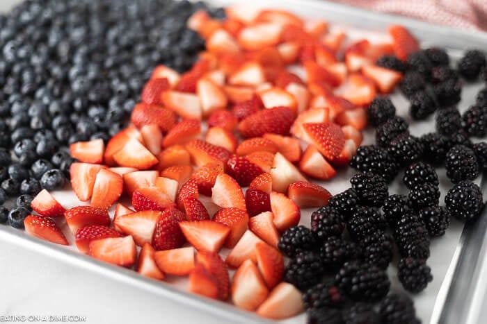 Blueberries, diced strawberries, and blackberries on a baking sheet