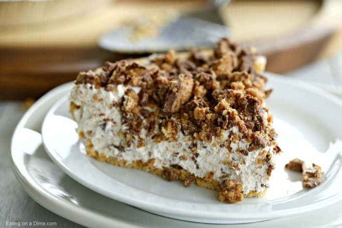 This Peanut Butter Reese’s Pie Recipe is the perfect no bake dessert. Reese's peanut butter pie recipe is delicious. Try Reese's chocolate peanut butter cup pie for an easy dessert recipe. This is the best Peanut Butter Pie easy no bake recipe. The entire family will love Reese’s Chocolate Peanut Butter Pie Recipe! #eatingonadime #pierecipes #dessertrecipes #reesesrecipes #easydesserts Close up image of a Reese's candy Peanut Butter pie on a plate.