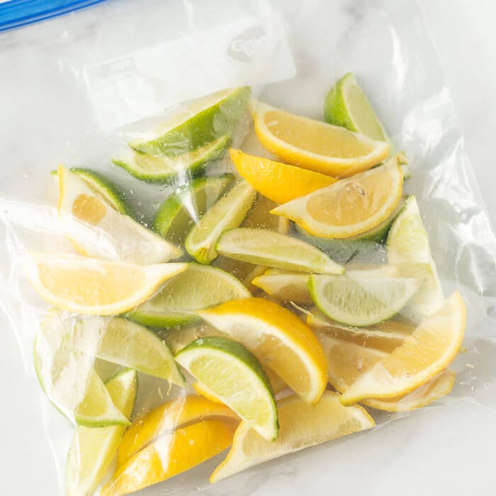 Learn how to freeze lemons and limes either whole or in slices. I love freezing citrus to save to use for juice, zest or for water. How to freeze lemons is easier than you think think! #eatingonadime #freezinglemons #freezingcitrus #freezertips 