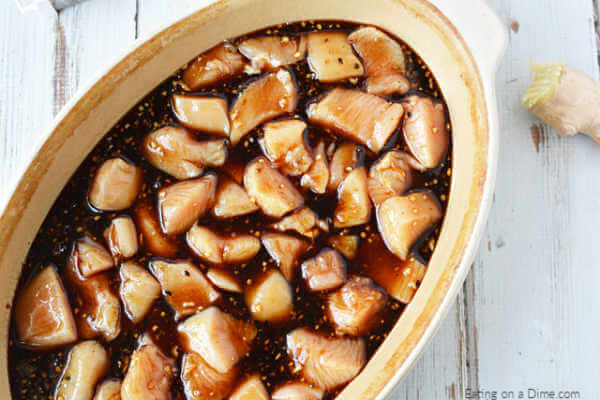 Close up image of teriyaki chicken unbaked in a baking dish. 