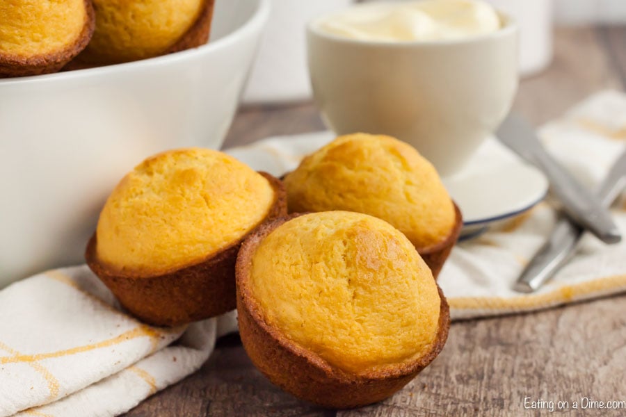 corn muffins in front of a bowl of corn muffins