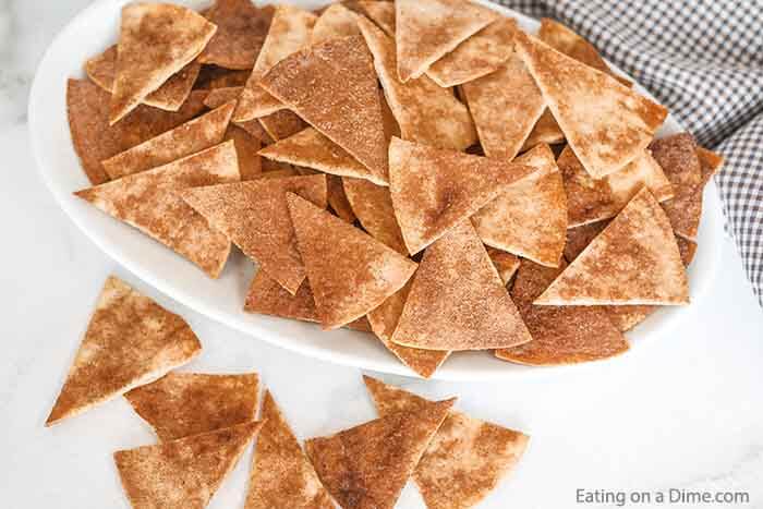 Cinnamon Chips make a delicious and easy dessert or snack idea. With only 4 ingredients, homemade cinnamon chips can be ready in minutes. #eatingonadime #easydessertrecipes #recipestortilla #simpledessertrecipes 