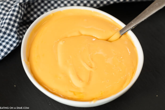 Learn how to make an easy American Cheese Sauce that is low carb with no flour and is perfect for broccoli and for pretzels. This quick and easy cheese sauce is great for fries and for veggies! You are going to love this melted easy cheese sauce for broccoli recipe with only 2 ingredients! #eatingonadime #cheesesaucerecipes #easyrecipes 
