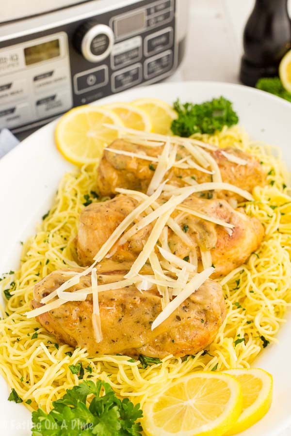 Lemon chicken on spaghetti noodles on a plate