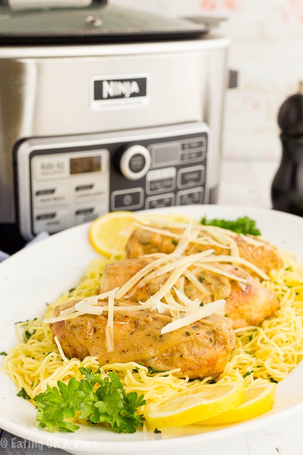 Lemon chicken on spaghetti noodles on a plate