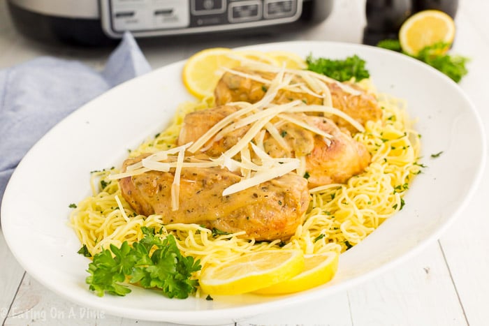 Lemon chicken on spaghetti noodles on a plate