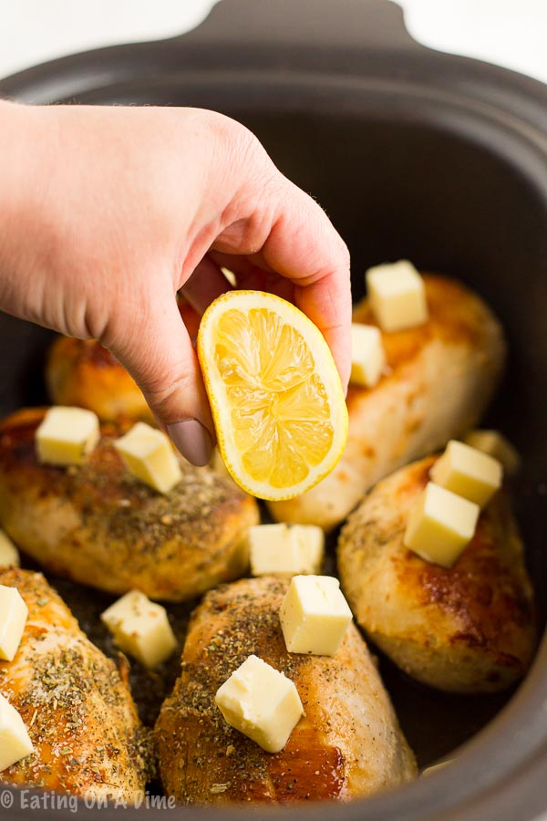 Topping the chicken with butter and fresh lemon
