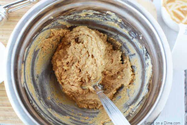 Close up image of the peanut butter mixture in a bowl with a spoon. 