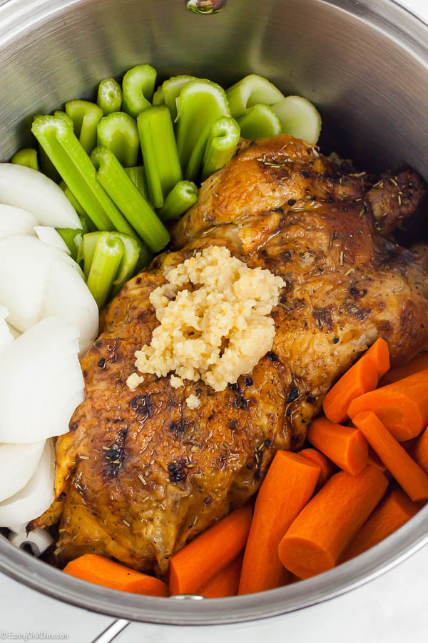 cooked chicken with minced garlic, carrots, celery and onion in a large pot