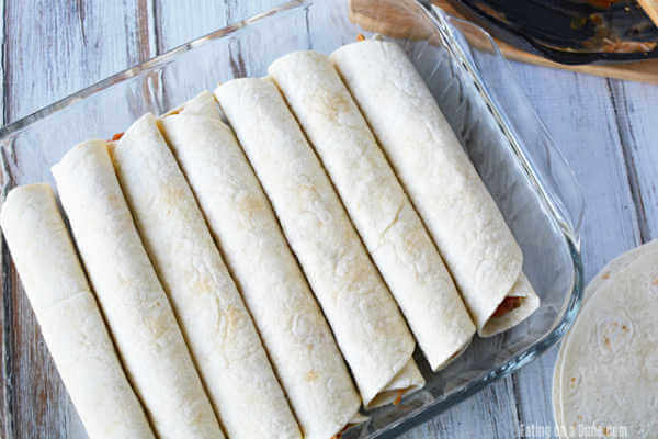 The tortillas rolled around the chicken mixture and placed in a baking pan.  