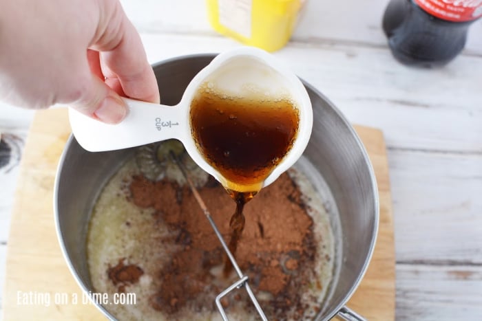 Adding the coca cola to the icing mix