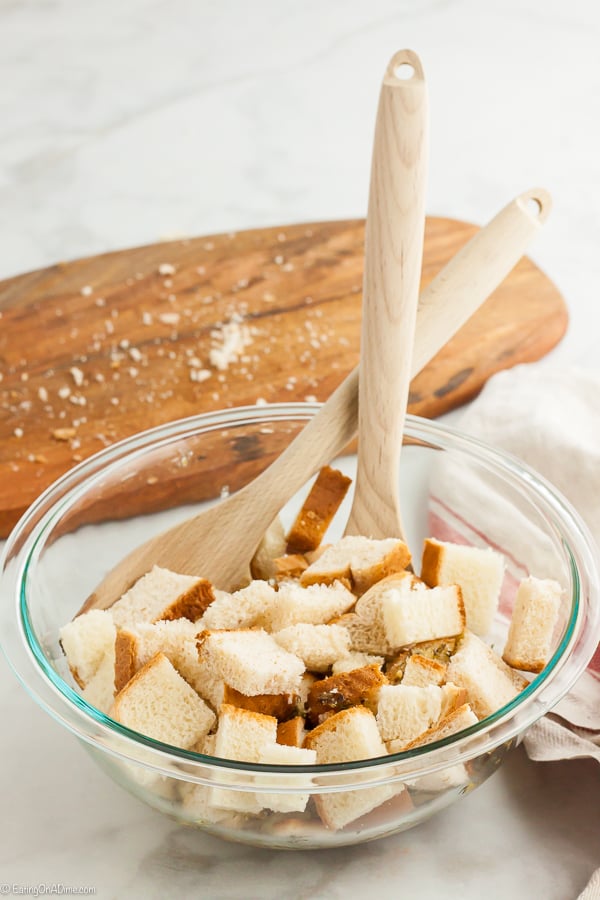 Combining the diced bread in a bowl with the seasoning with wooden spoons