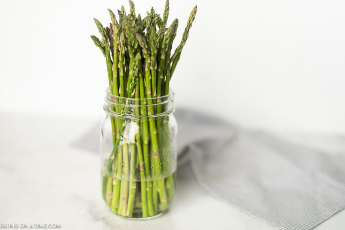 Did you know there is a right way to store asparagus?! Learn how to store asparagus in the fridge so it’ll stay fresh and last longer. Check out how to store asparagus fresh so it doesn’t go back right away! #eatingonadime #storingasparagus #keepingproducefresh 