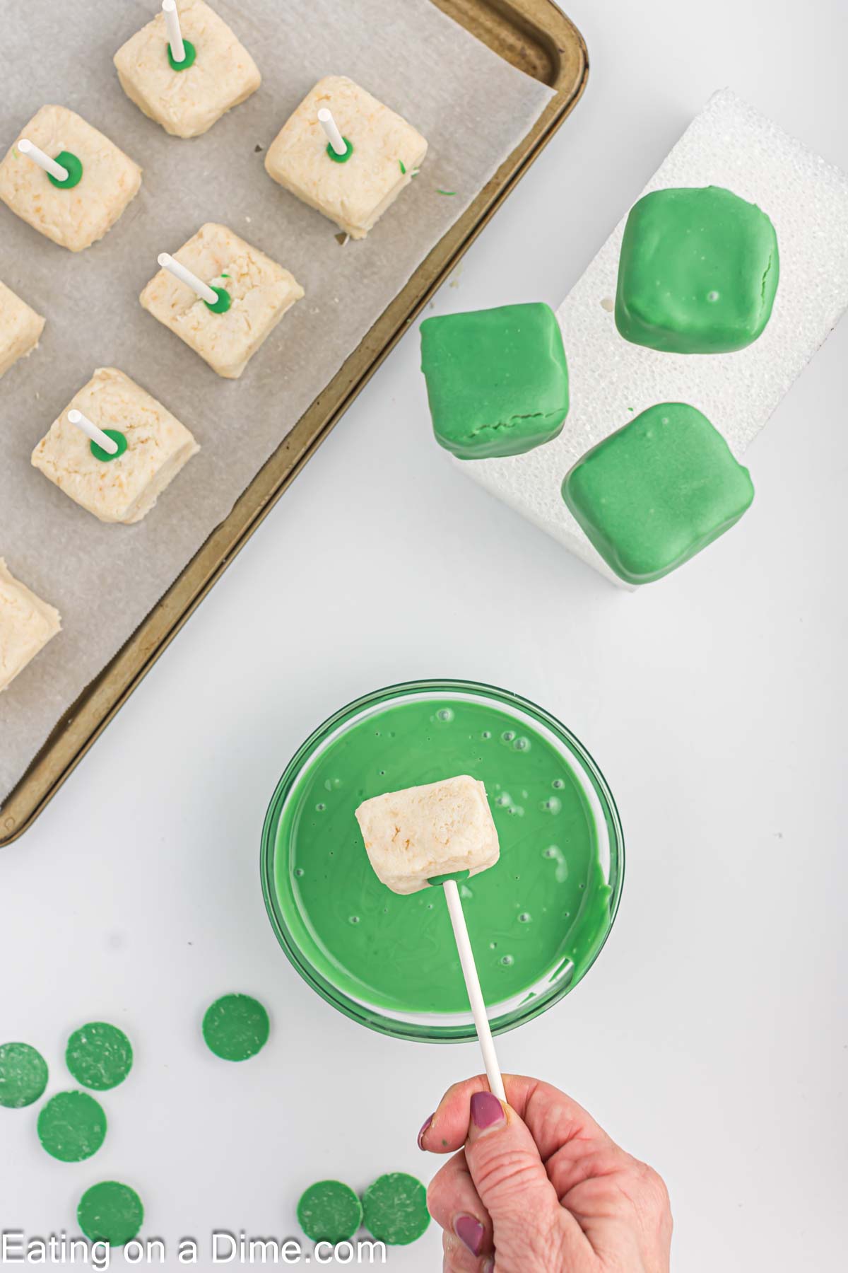 Dipping the square cake pops into the melted green chocolate