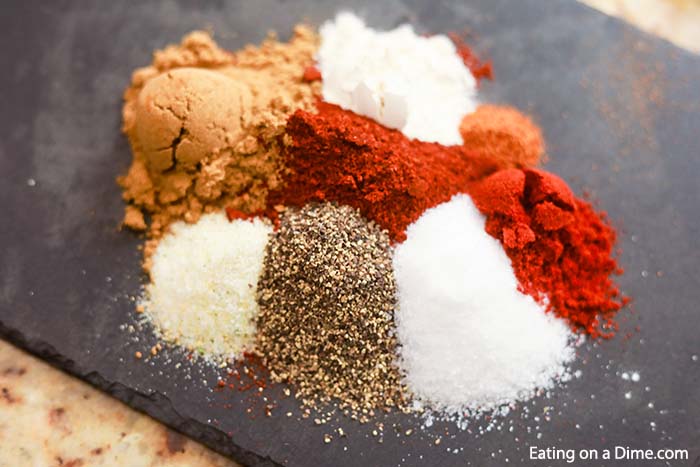 Close up image of all the ingredients for the taco seasoning sprinkled on a board. 