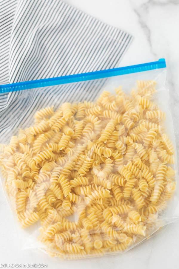 Cooked rotini pasta in a large freezer bag with the bag sealed and the air removed.  