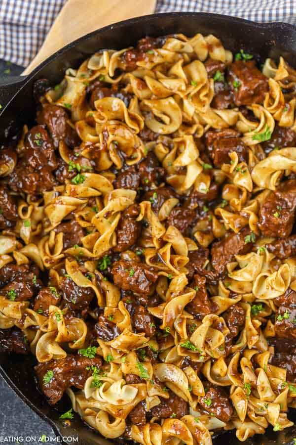 Close up image of beef and noodles in a iron skillet. 
