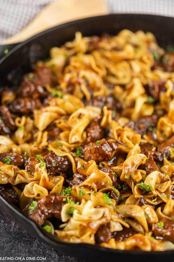Close up image of beef and noodles in a iron skillet. 
