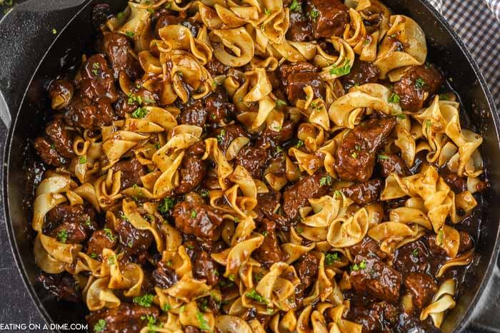Close up image of beef and noodles in an iron skillet. 