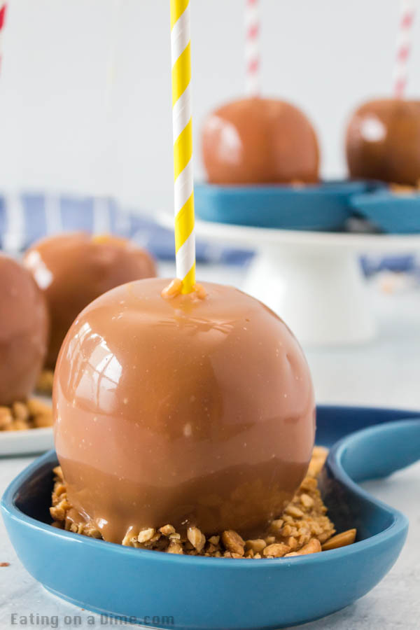 Learn how to make homemade caramel apples. They are so easy to make with a few simple ingredients and you dip each apple. Perfect for your next party or Halloween carnival! This is this best DIY caramel apples recipe. #eatingonadime #applerecipes #caramelapples 