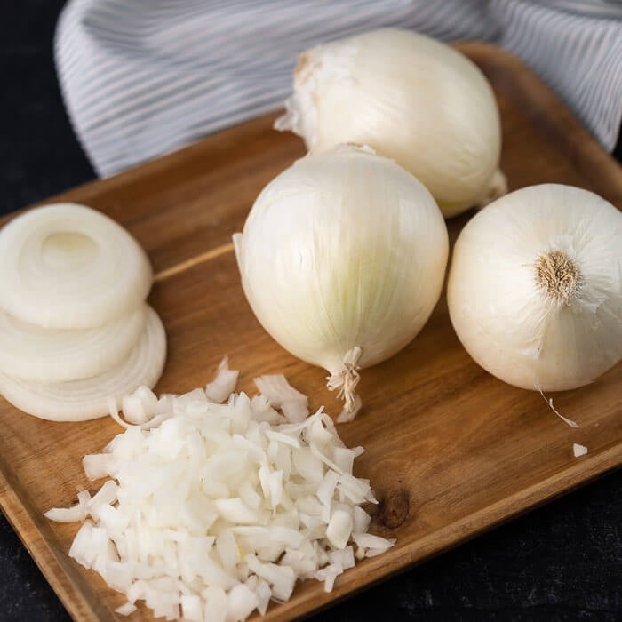 Chopped Onions, Sliced Onions and Whole Onions on a Cutting Board