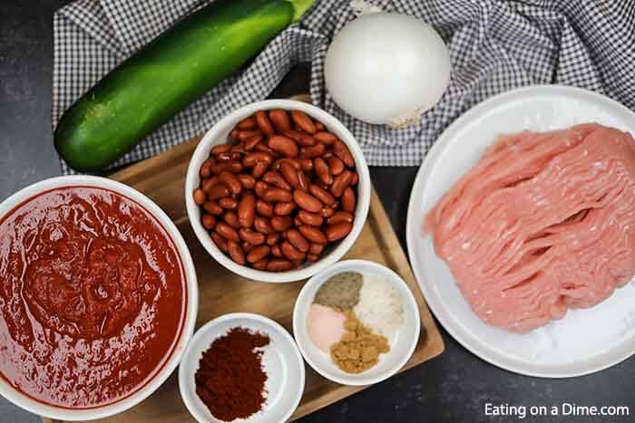 Close up image of ingredients for turkey chili - turkey, onion, beans, crushed tomatoes and seasoning. 