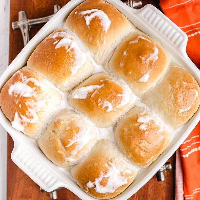 close up image of a pan of hawaiian rolls with butter on top. 