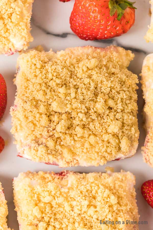 These strawberry crunch bars are easy to make and very delicious! This no bake strawberry crunch bars recipe with cookies is perfect for any occasion. These strawberry cookie bars are simple to make. You are going to love these strawberry crumb bars! #eatingonadime #easydesserts #strawberrydesserts 