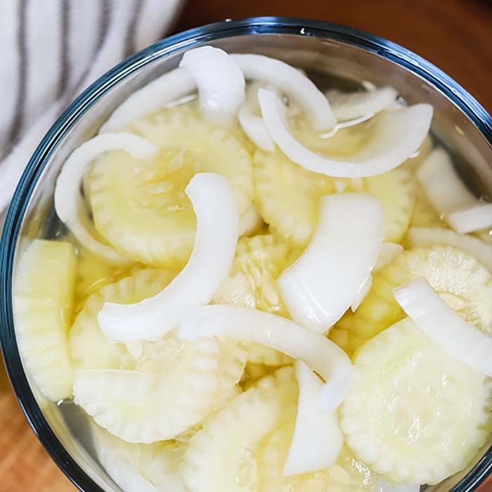 This simple and inexpensive Cucumber Onion Salad Recipe is simply fabulous! The flavor is amazing but it is just so easy to prepare and the best side dish. Cucumber Onion Salad in a clear bowl