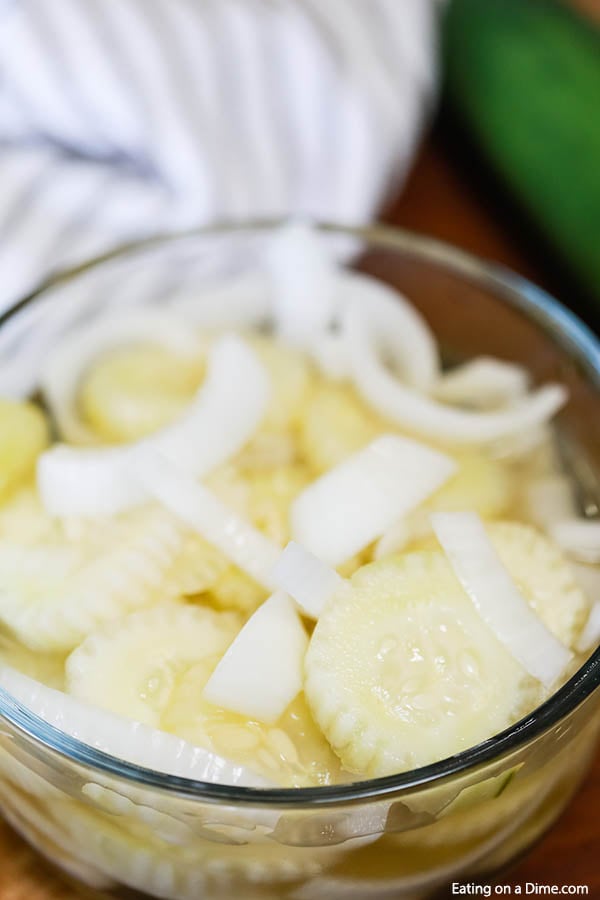 This simple and inexpensive Cucumber Onion Salad Recipe is simply fabulous! The flavor is amazing but it is just so easy to prepare and the best side dish. Cucumber Onion Salad in a clear bowl