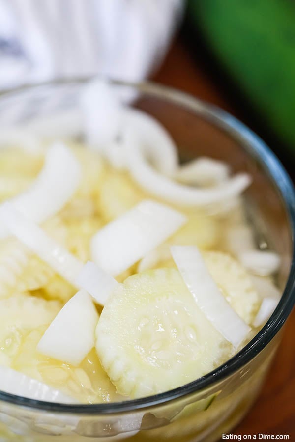 This simple and inexpensive Cucumber Onion Salad Recipe is simply fabulous! The flavor is amazing but it is just so easy to prepare and the best side dish. Cucumber Onion Salad in a clear bowl