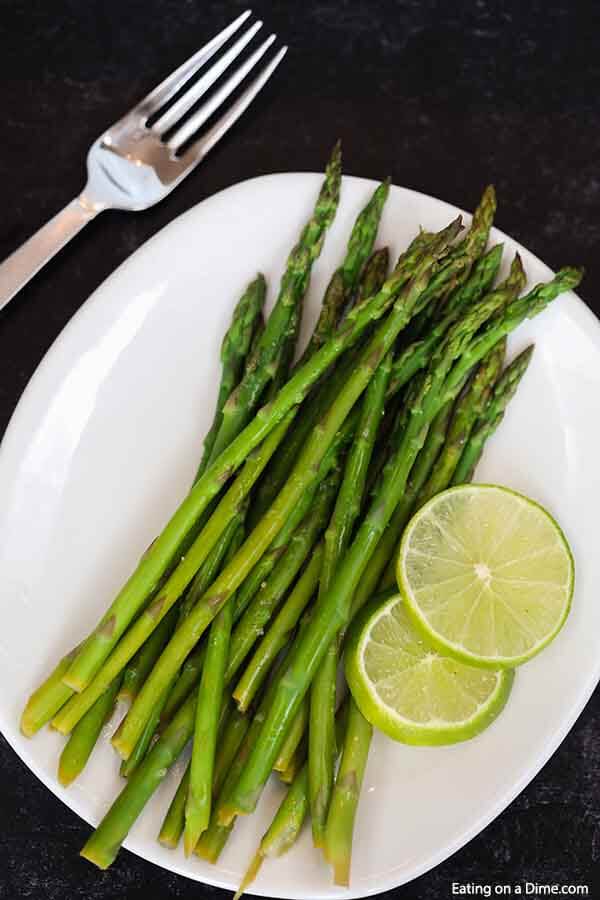 This Garlic Lime Steamed Asparagus is the perfect easy side dish to any meal. Learn how long do you steam asparagus on the stove top for the best Garlic Lime Steamed Asparagus in only 10 minutes. Learn how to make this easy vegetable recipe on stove. This is one of my favorite steamed asparagus recipe. Learn how long to steam asparagus and how to cook asparagus perfectly every time! #eatingonadime #sidedishrecipes #steamedasparagus #easyvegetablerecipes 