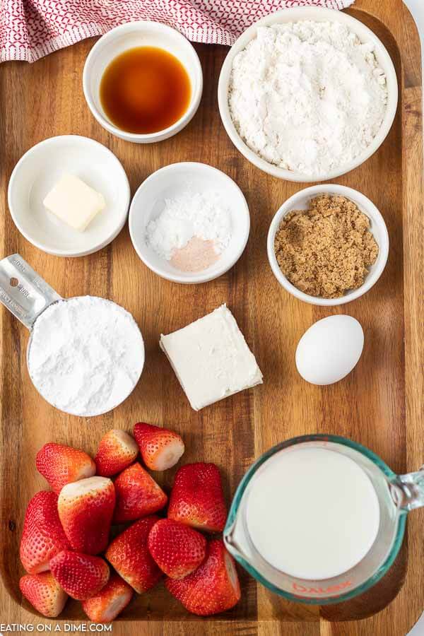 Picture of ingredients: vanilla, flour, butter, brown sugar, cream cheese, egg, strawberry, milk.