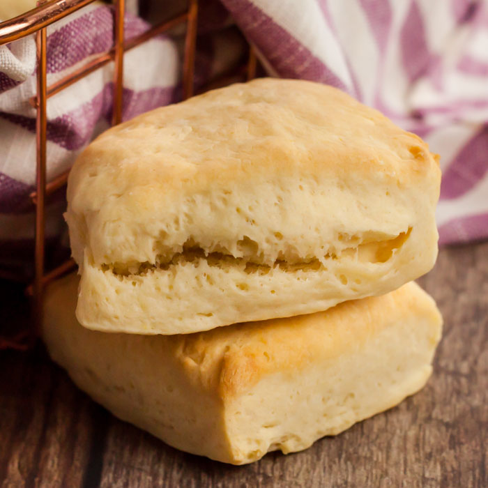 Close up image of two biscuits next to a wired basket with a hand towel. 