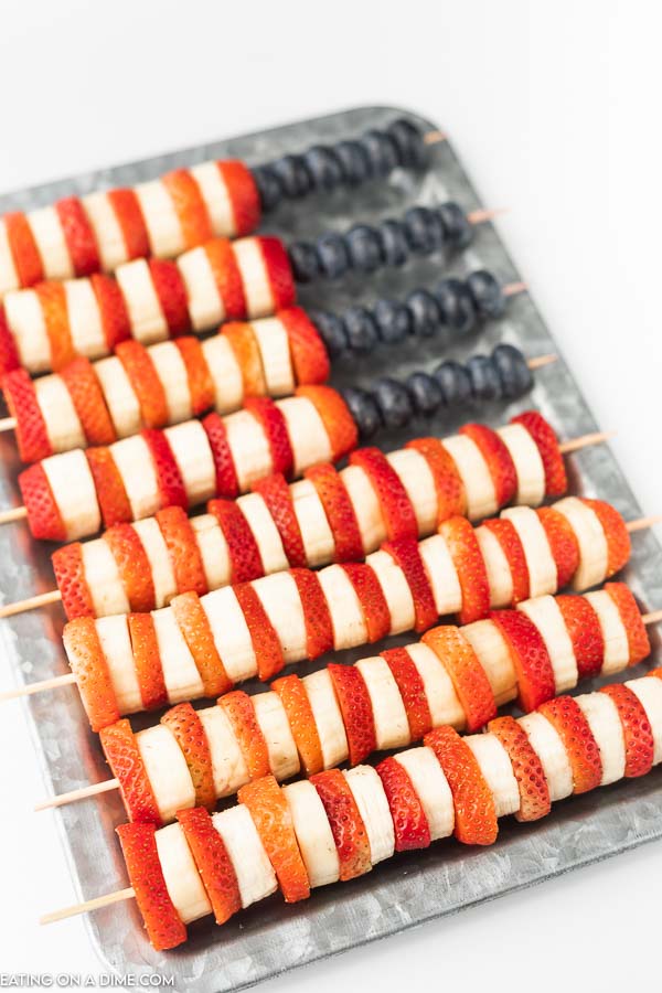 Closeup photo of red, white and blue fruit skewers on a platter.