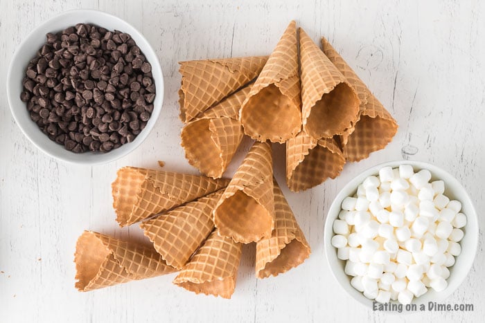 Check out how to make s’mores campfire cones that are fun and less messy than traditional s’mores. Camp fire cones are a blast and fun to make. Campfire sugar cone s’mores are a fun and easy dessert for any camping treat. Campfire s’mores cones will be your favorite summer treat! #eatingonadime #smoresrecipes #campfirecones #easydesserts 