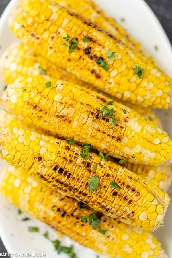 picture of grilled corn on cob on a platter.