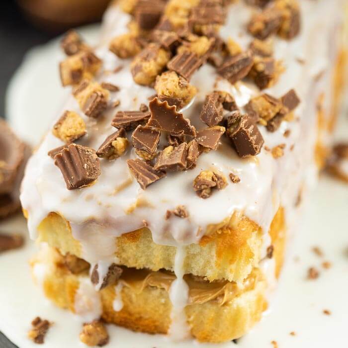 Close up of the white chocolate peanut butter cake with peanut butter cups sprinkled on top of it. 