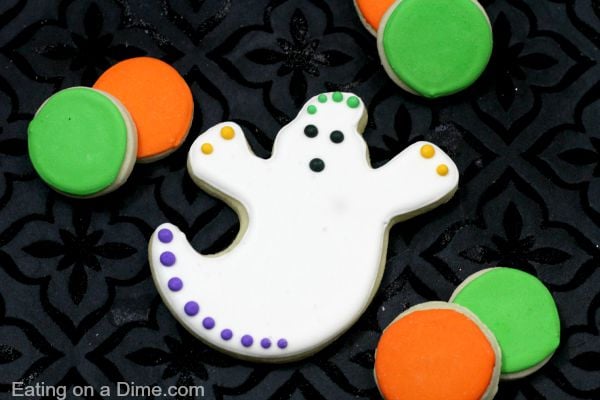 You just have to make these cute Ghost Cookies decorated with royal icing for Halloween. The kids will love decorating them and they are super easy to make! This DIY Ghost sugar cookies recipe is the best and perfect for any party or get together this year! #eatingonadime #cookierecipes #halloweendesserts #ghostcookies