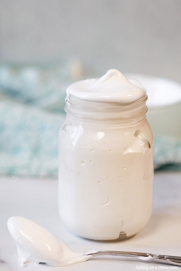 Close up image of Marshmallow Cream in a mason jar with a serving on the spoon. 