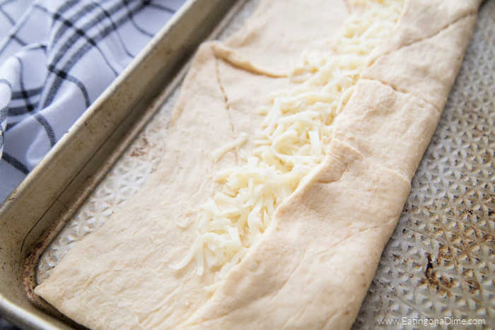 You just have to make this Stuffed Cheesy Bread Recipe with crescent rolls. This is the best cheesy bread and it only takes 15 minutes to make! Try this easy bread recipe. #eatingonadime #appetizerrecipes #breadrecipes