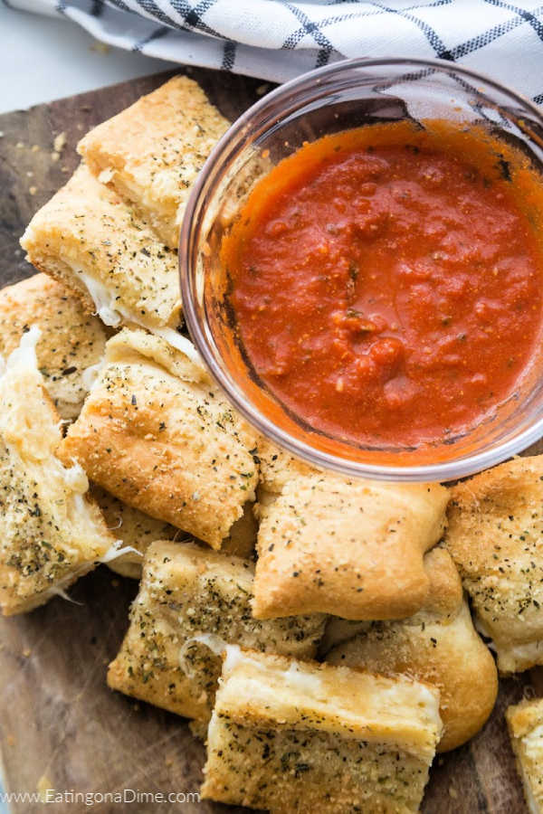 Cheesy bread stacked with a side of marinara sauce
