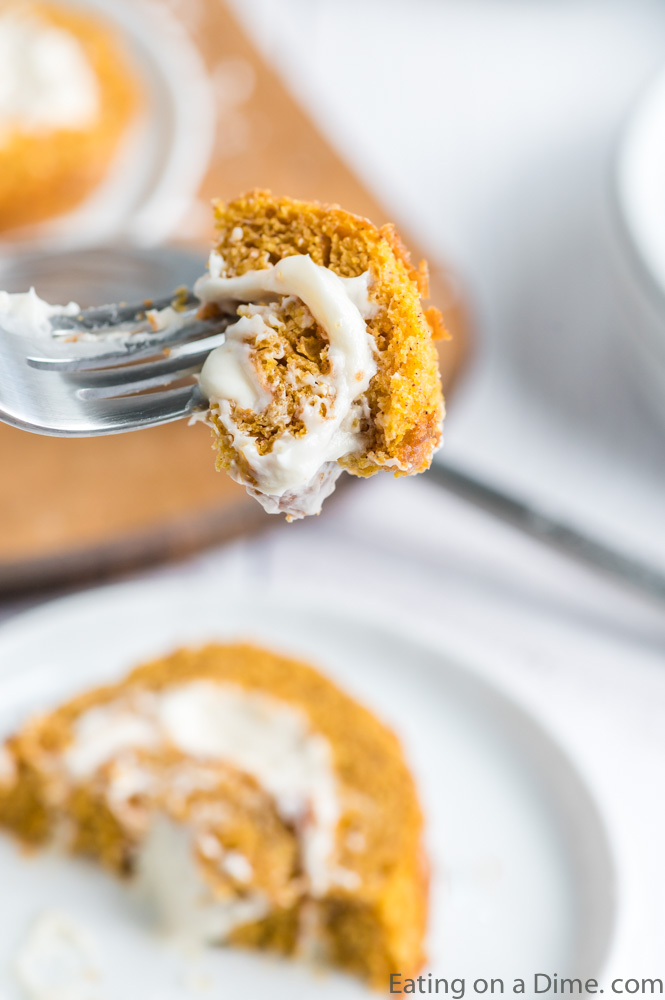 Close up image of a slice of pumpkin roll with a bite on a fork.