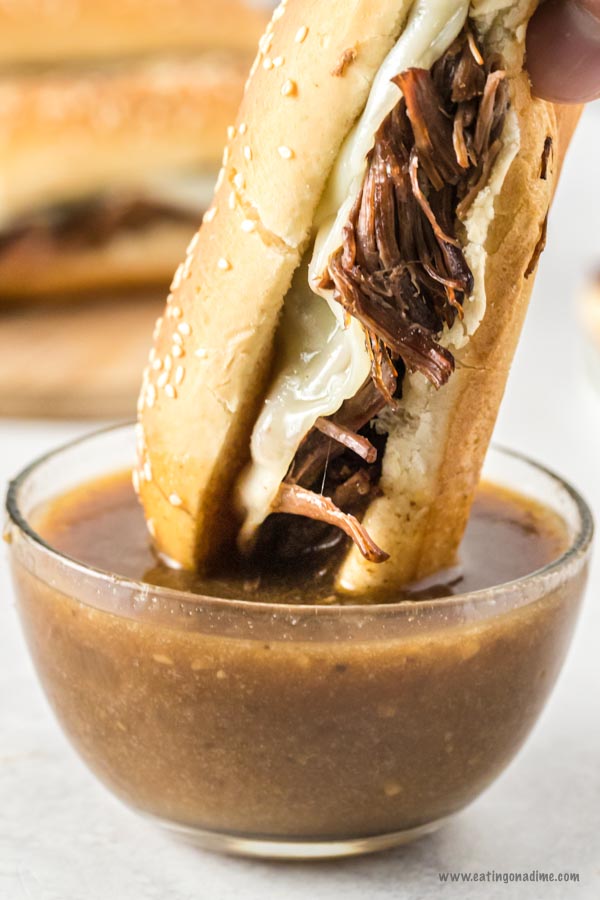 Dipping the French Dip Sandwiches in a the Au Jus Gravy