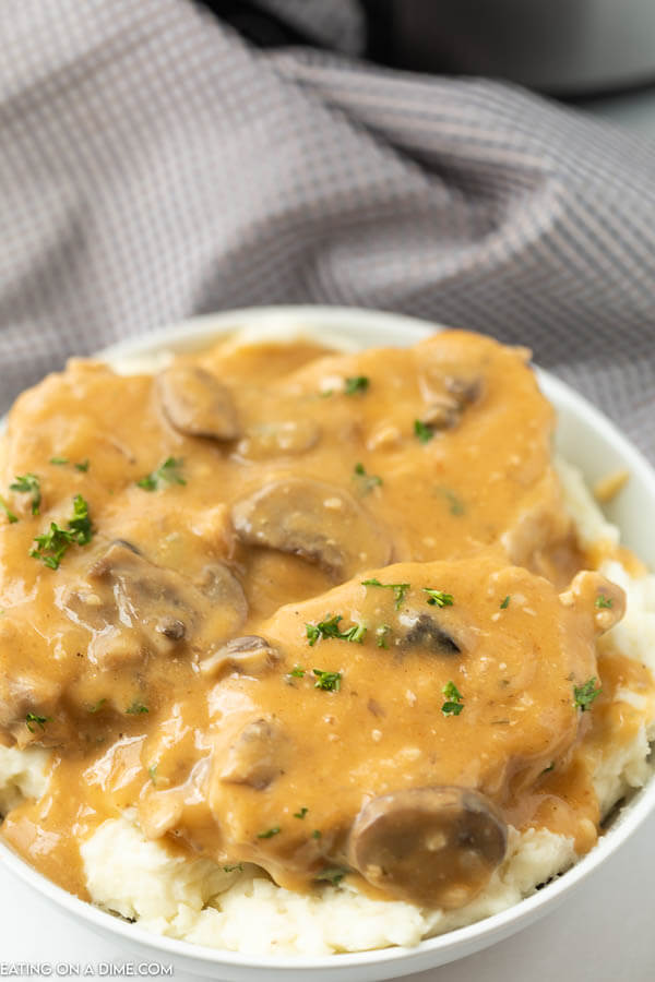 Close up image of smother pork chops on mashed potatoes. 