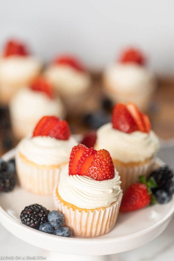 These Angel Food Cupcakes from mix boxes are easy to make and are low calorie (under 60 calories). These healthy angel food cupcakes with frosting and with strawberries are light as air and tastes delicious! You are going to love these strawberry angel food cupcake recipe. #eatingonadime #cupcakerecipes #angelfoodrecipes #angelfoodcupcakes 
