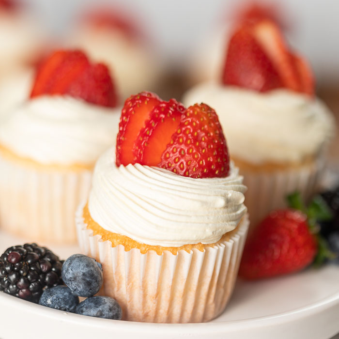 These Angel Food Cupcakes from mix boxes are easy to make and are low calorie (under 60 calories). These healthy angel food cupcakes with frosting and with strawberries are light as air and tastes delicious! You are going to love these strawberry angel food cupcake recipe. #eatingonadime #cupcakerecipes #angelfoodrecipes #angelfoodcupcakes 